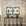 Contemporary living space with abstract beige and taupe brushstroke grasscloth wallpaper, a sleek black console table, and two symmetrical geometric framed artworks.