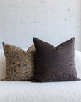 Dark brown sunburst pillow styled with dark brown botanical leaf pillows on white boucle sofa