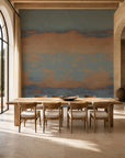 Blue and copper sunset ombre mural wallpaper installed in a sunlit dining room