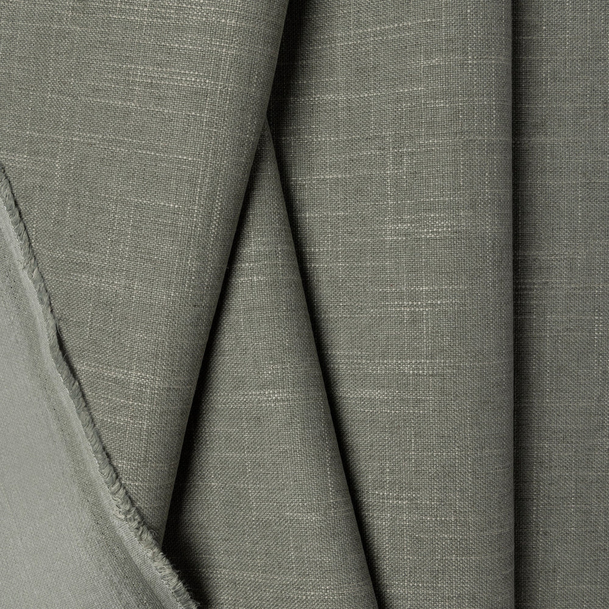 Green linen upholstery fabric by the yard, folded showing drape and weight
