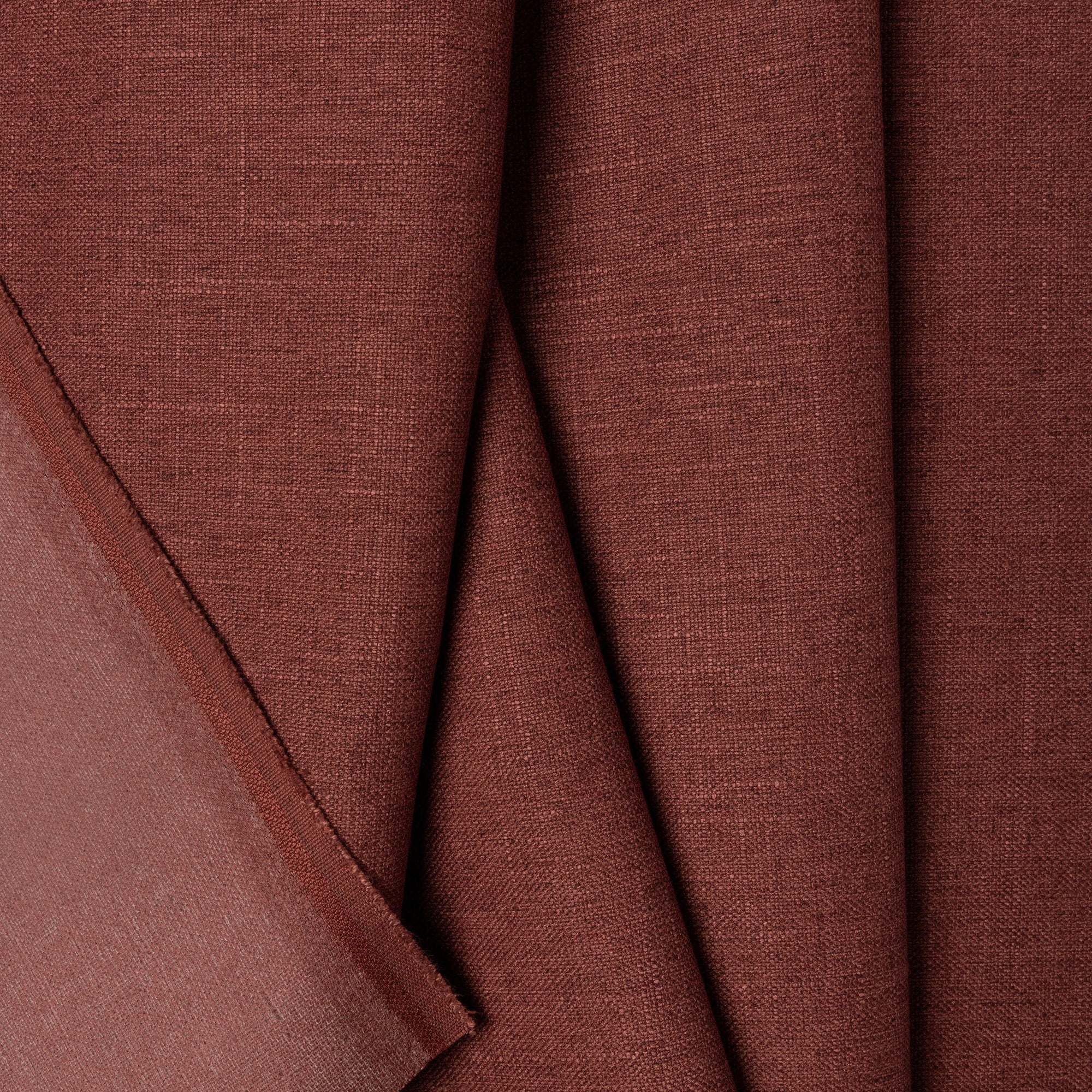 Red linen upholstery fabric by the yard, folded showing drape and weight