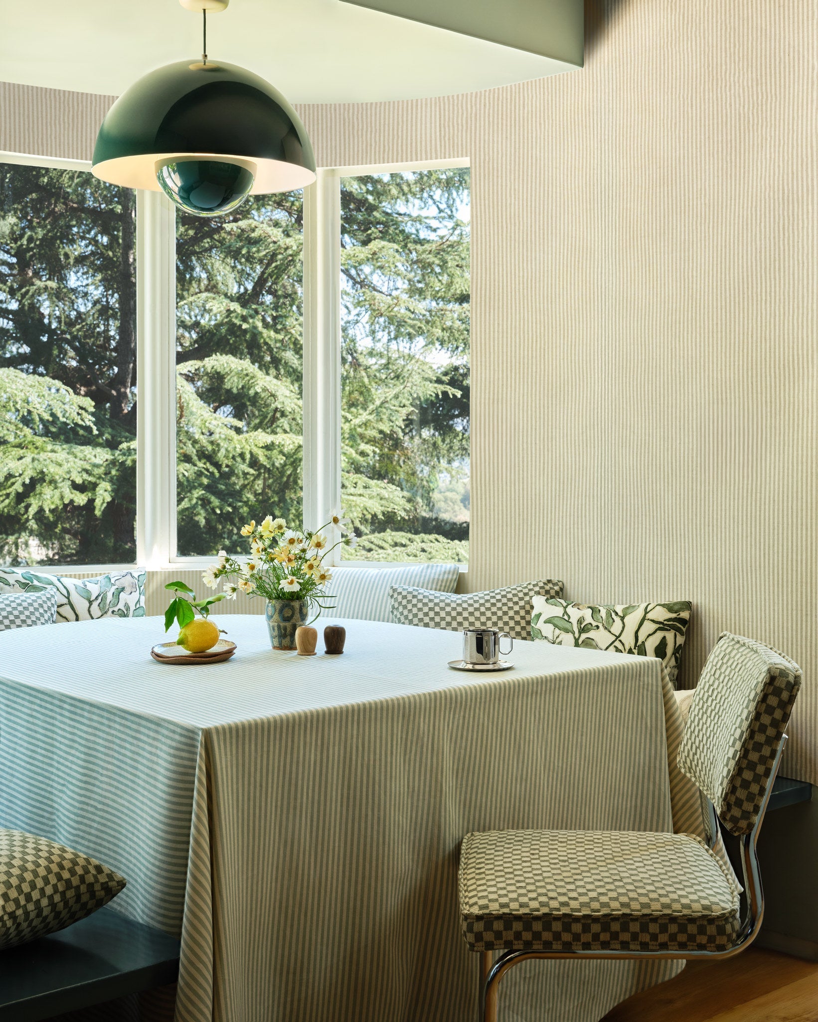 Brown striped linen wallpaper hung on the wall in a sunlit breakfast nook with checkerboard chairs