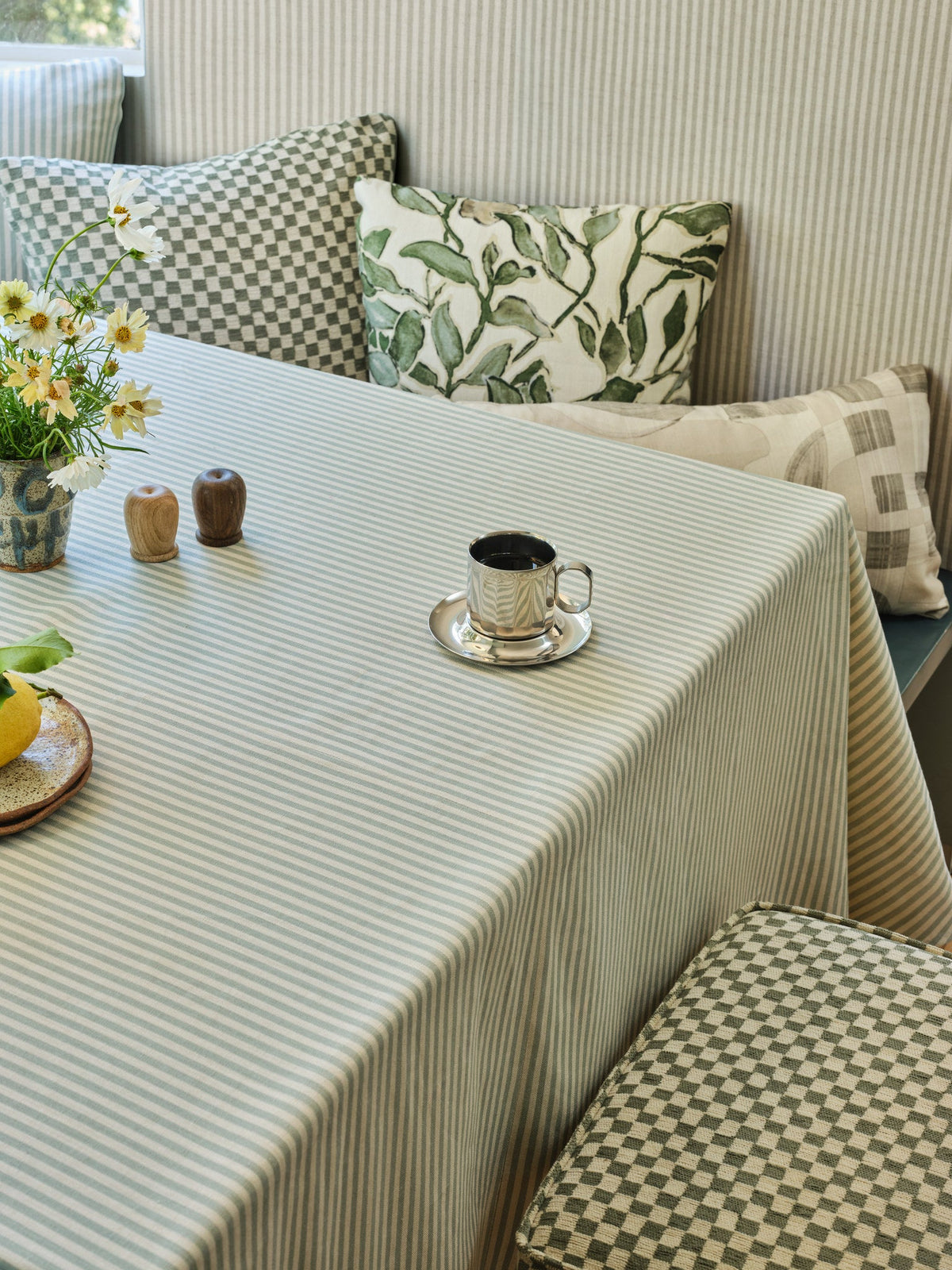 Blue and cream striped linen fabric used as a tablecloth on a nook table set with an espresso cup