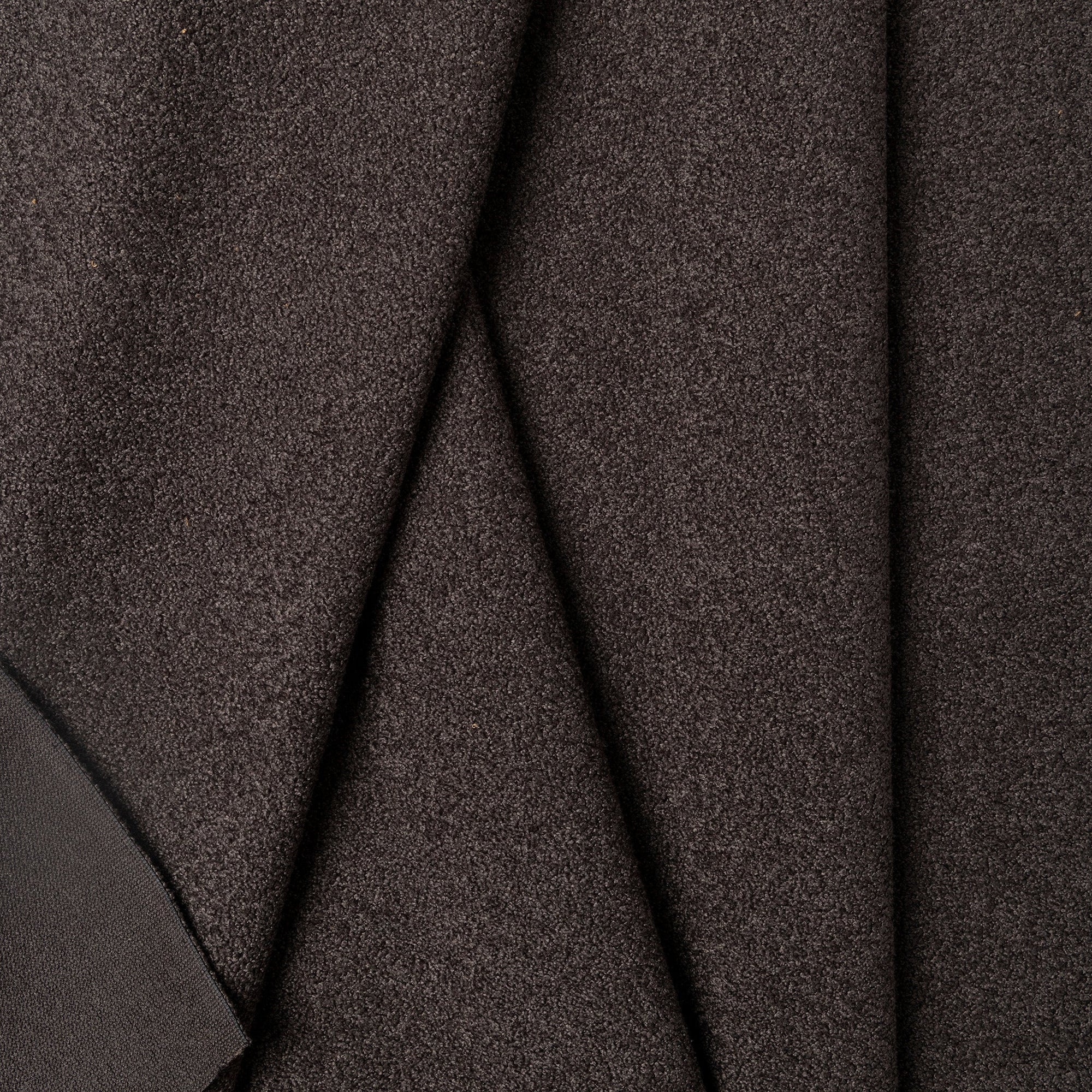 Black boucle upholstery fabric by the yard, folded showing drape and weight