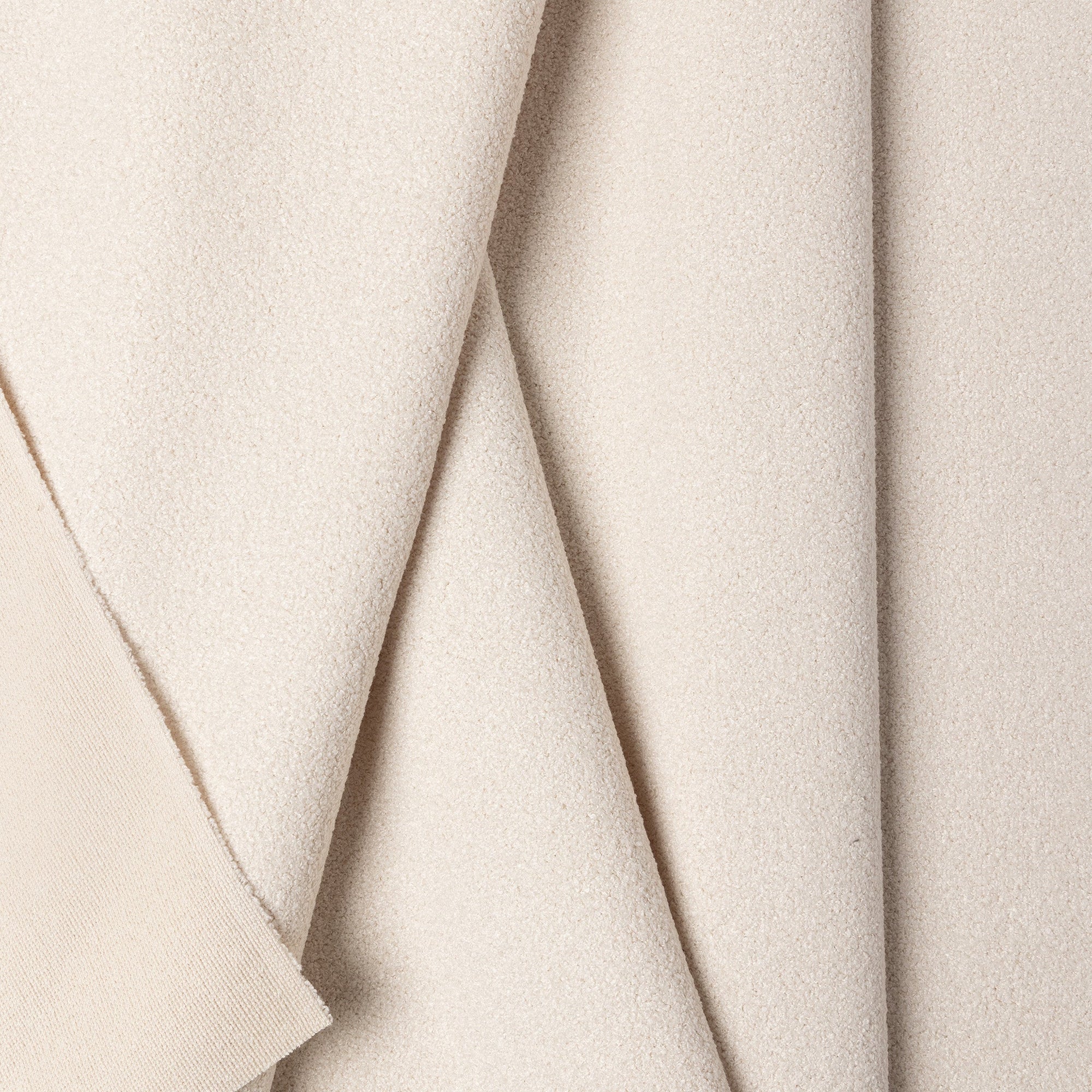 White boucle upholstery fabric by the yard, folded showing drape and weight