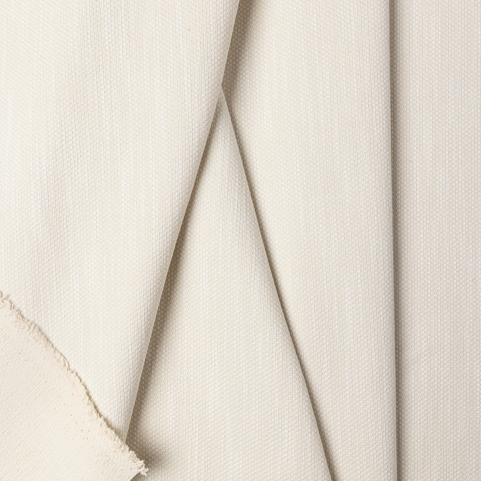 Cream basketweave upholstery fabric by the yard, folded showing drape and weight