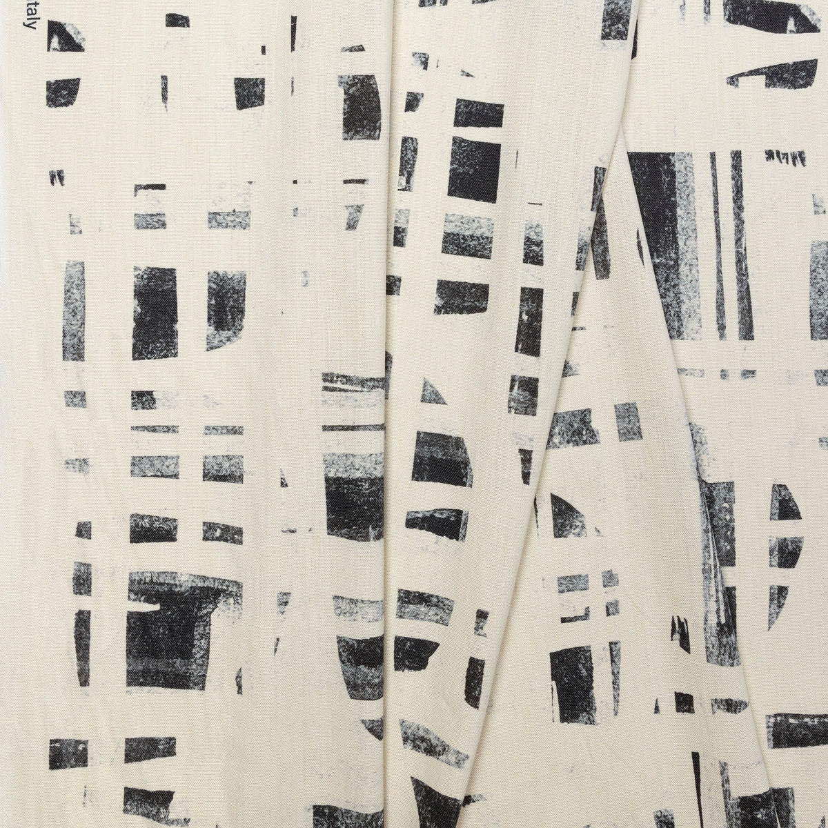 Cream and black brushstroke crosshatch linen fabric by the yard, folded showing drape and weight