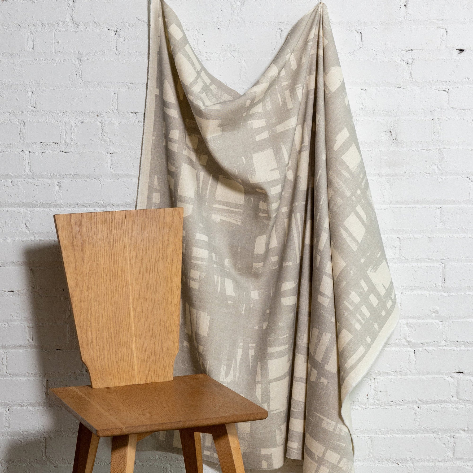 Natural cream brushstroke crosshatch linen fabric by the yard, draped to show pattern and scale