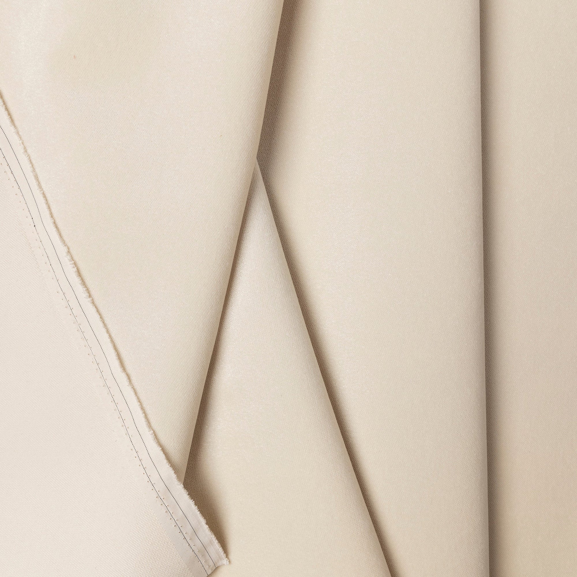 Cream velvet upholstery fabric by the yard, folded showing drape and weight