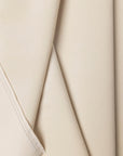 Cream velvet upholstery fabric by the yard, folded showing drape and weight