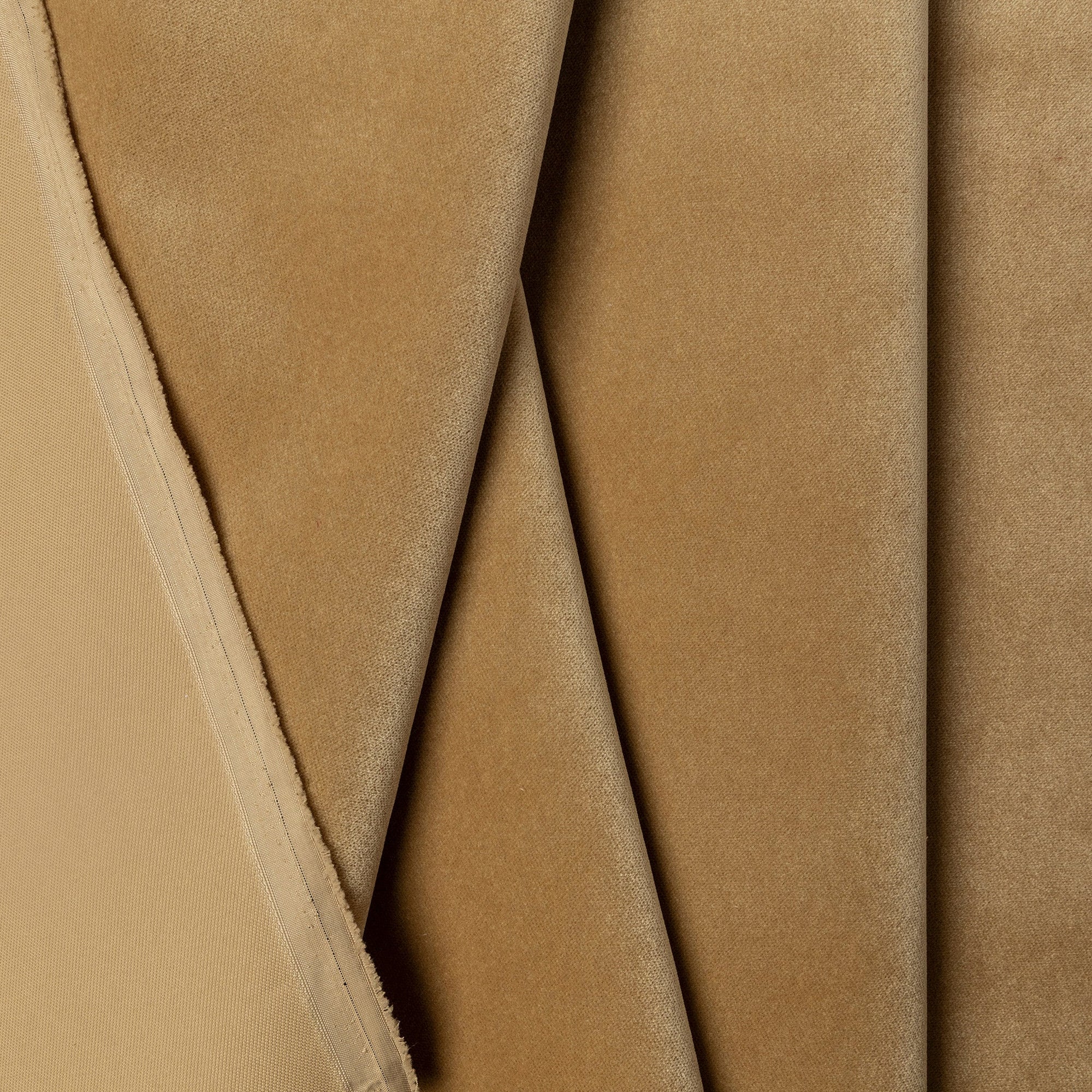 Gold velvet upholstery fabric by the yard, folded showing drape and weight