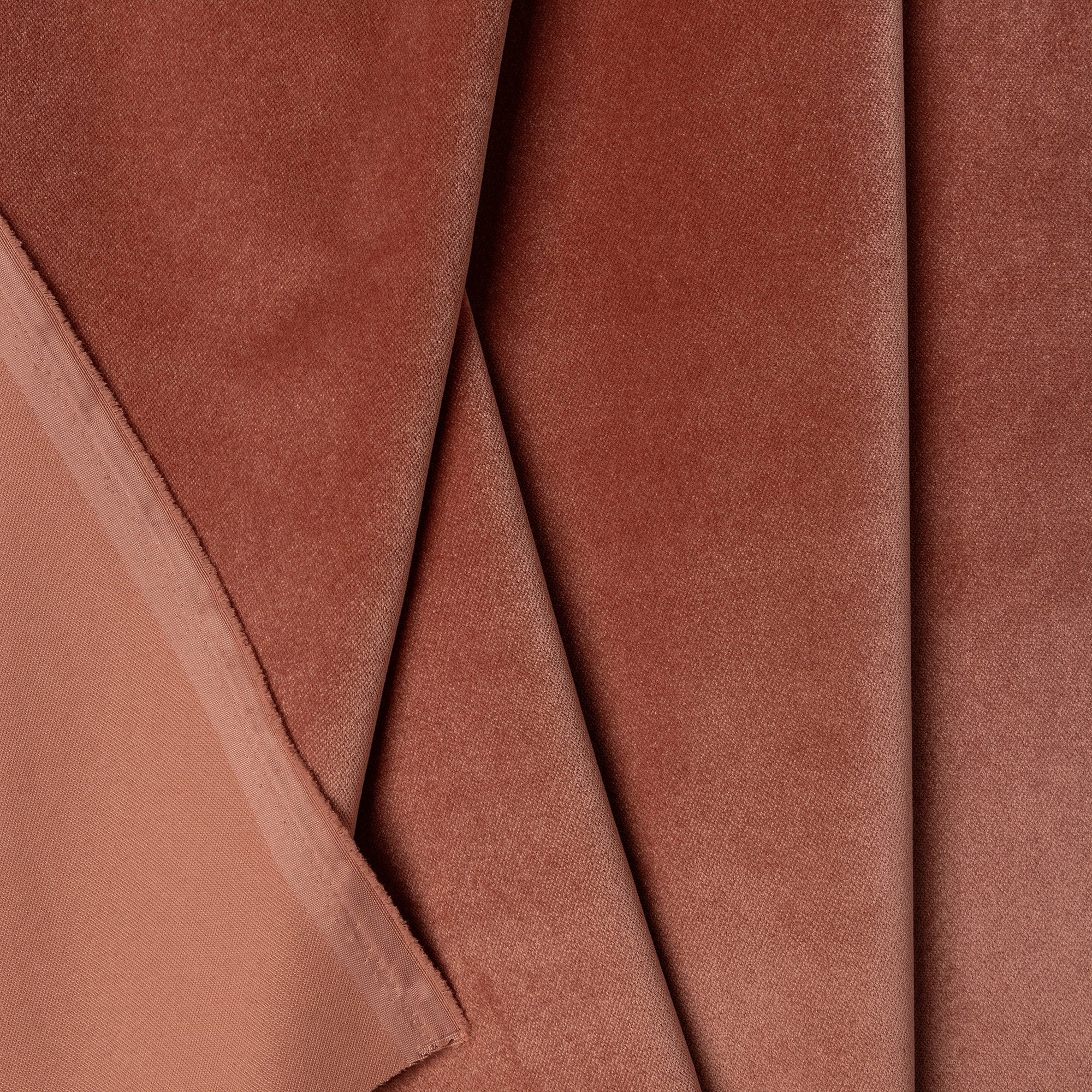 Pink velvet upholstery fabric by the yard, folded showing drape and weight