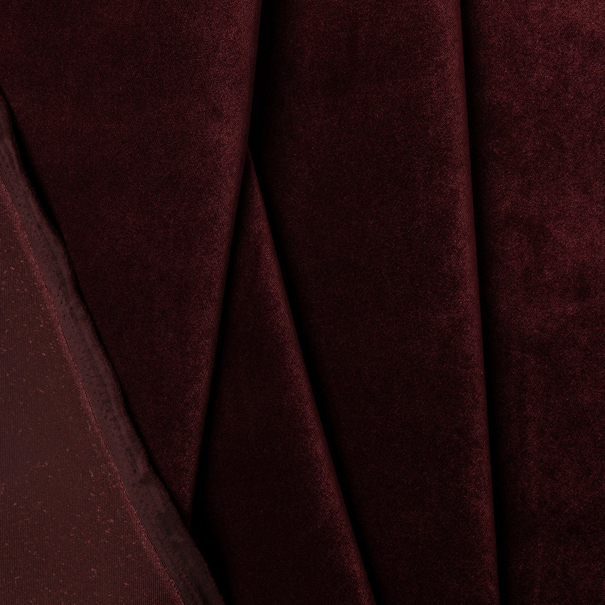 Red velvet upholstery fabric by the yard, folded showing drape and weight
