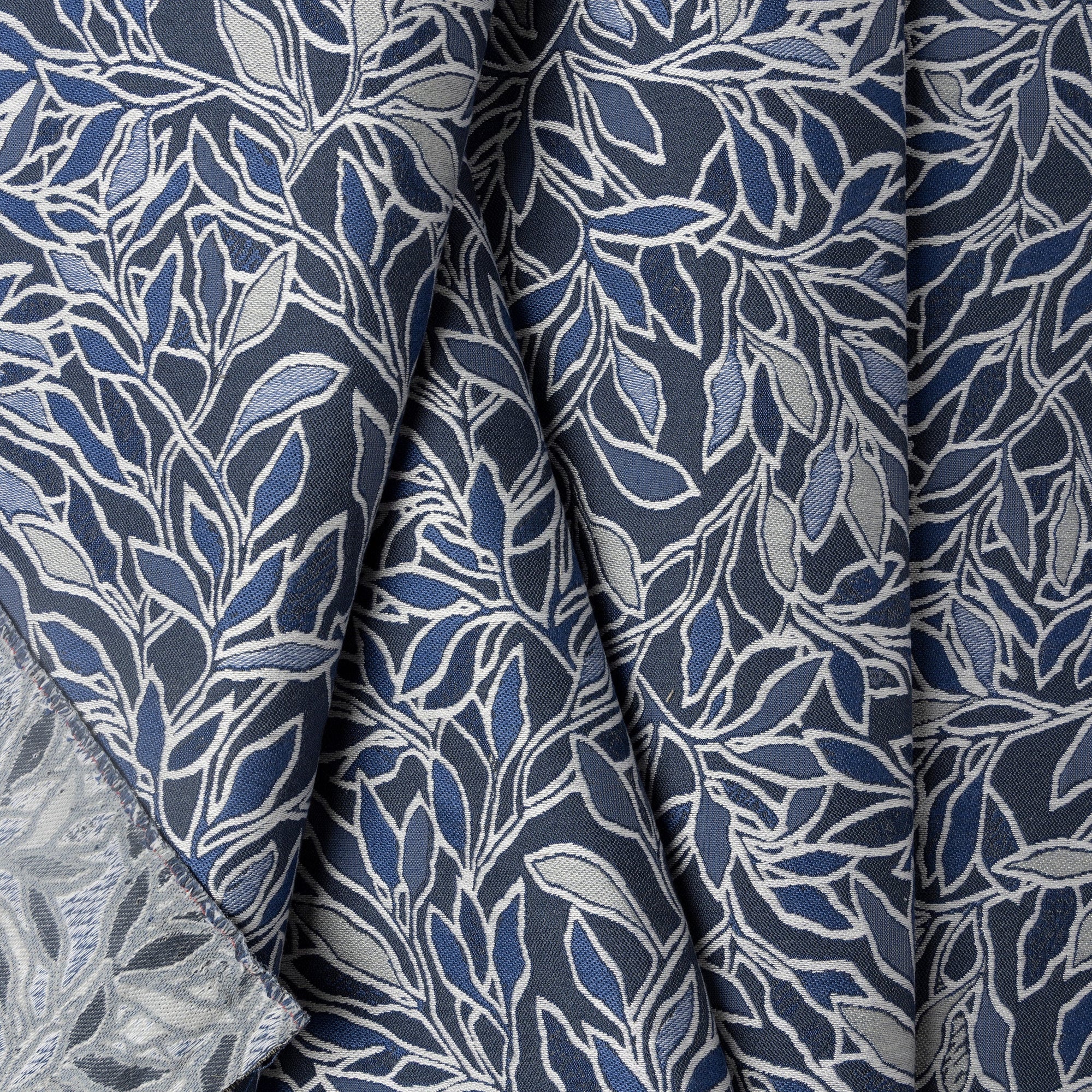 Blue and cream botanical leaf jacquard upholstery fabric by the yard, folded showing drape and weight