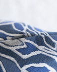 Close-up of woven botanical leaf pattern on blue and cream jacquard throw pillow