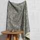 Blue botanical leaf printed linen fabric by the yard, draped to show pattern and scale