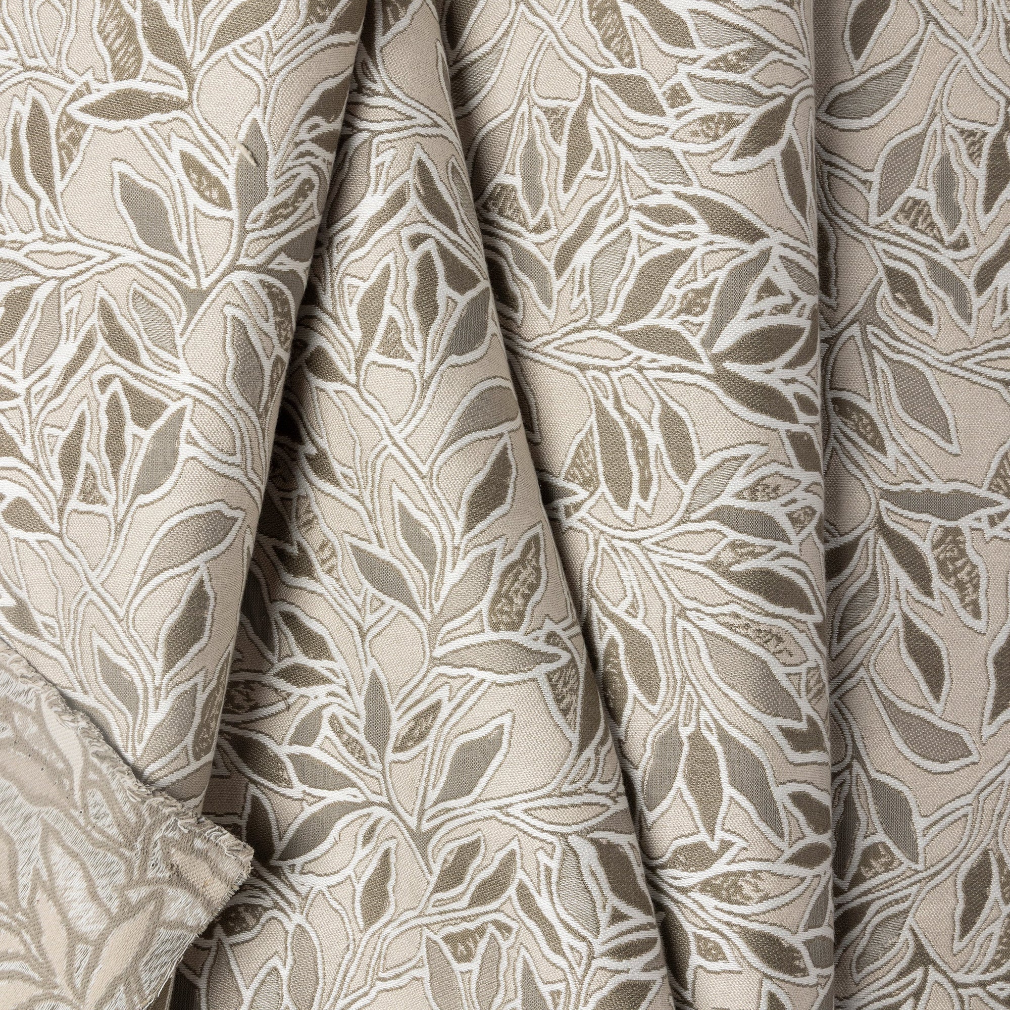 Cream botanical leaf jacquard upholstery fabric by the yard, folded showing drape and weight