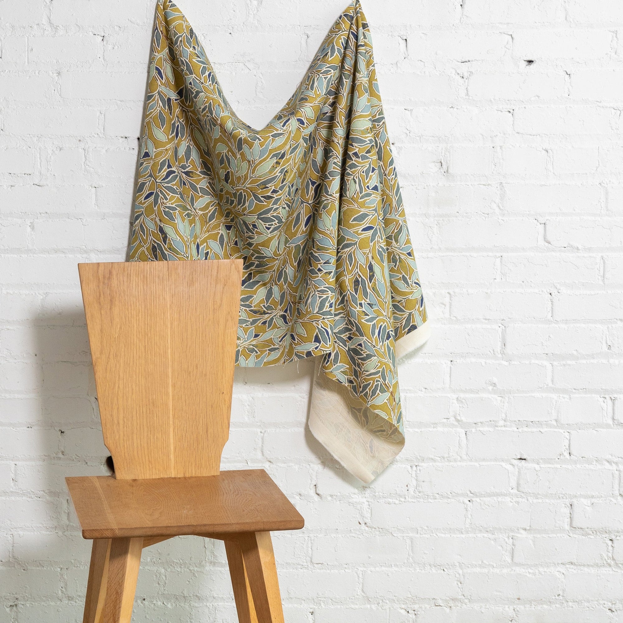 Multicolor botanical leaf printed linen fabric by the yard, draped to show pattern and scale