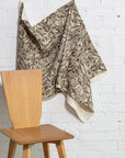 Brown and cream botanical leaf printed linen fabric by the yard, draped to show pattern and scale