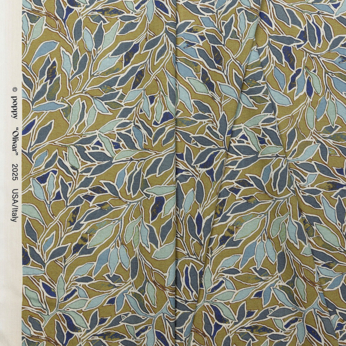 Olive gold and blue botanical leaf printed linen fabric by the yard, folded showing drape and weight