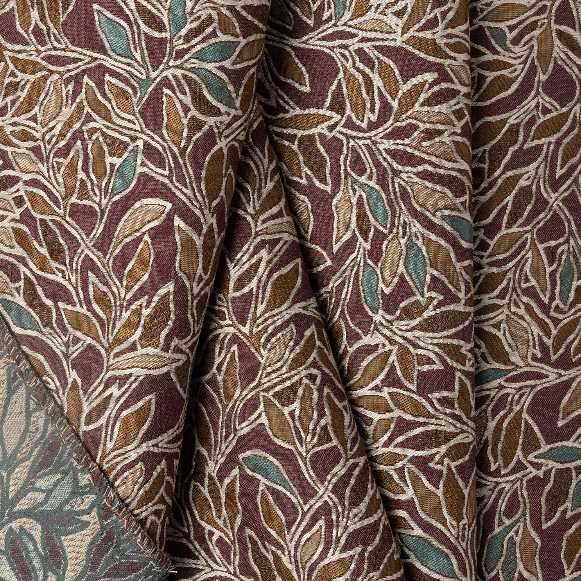 Deep maroon with teal botanical leaf jacquard upholstery fabric by the yard, folded showing drape and weight