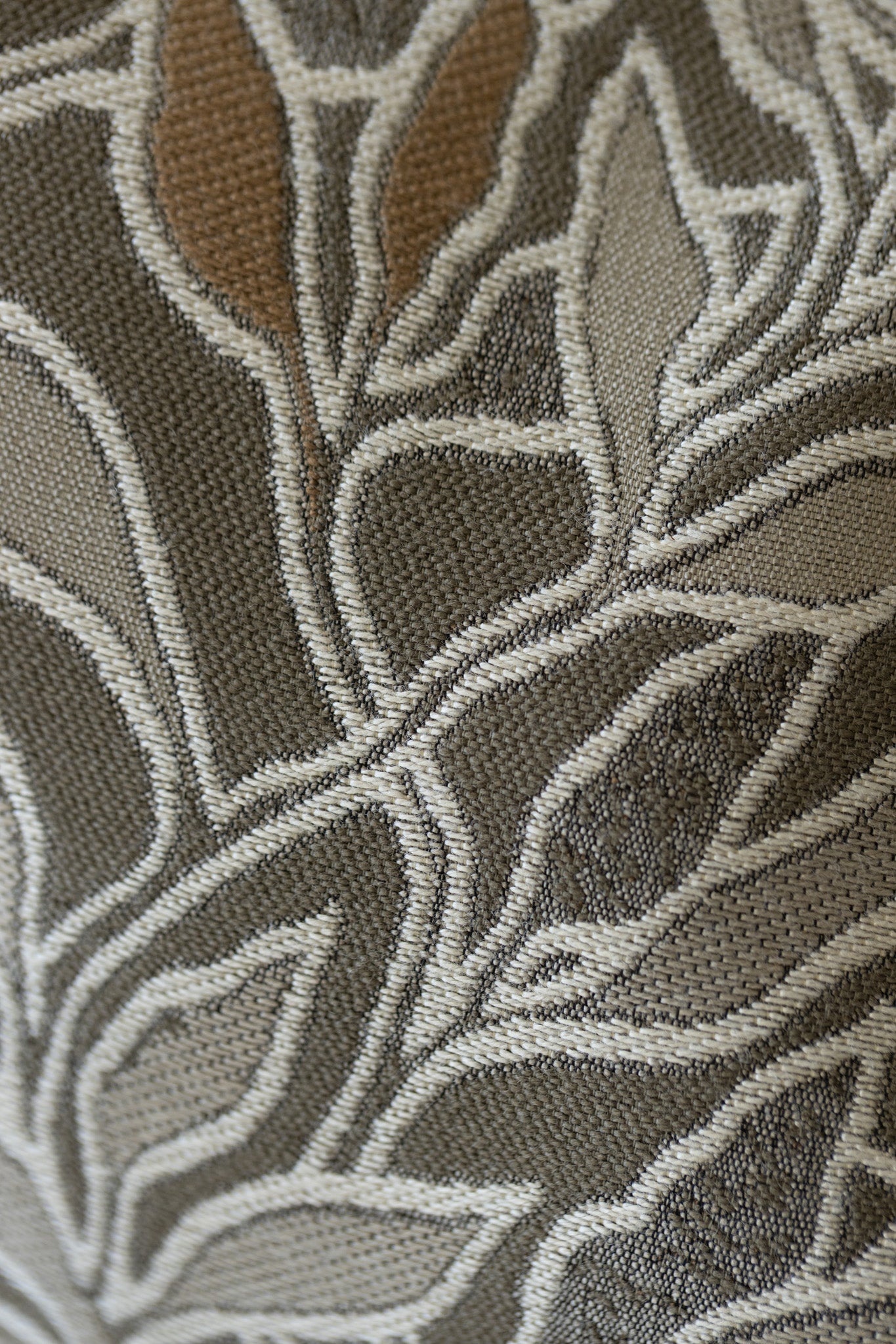 Close-up of woven botanical leaf pattern on sage green jacquard throw pillow