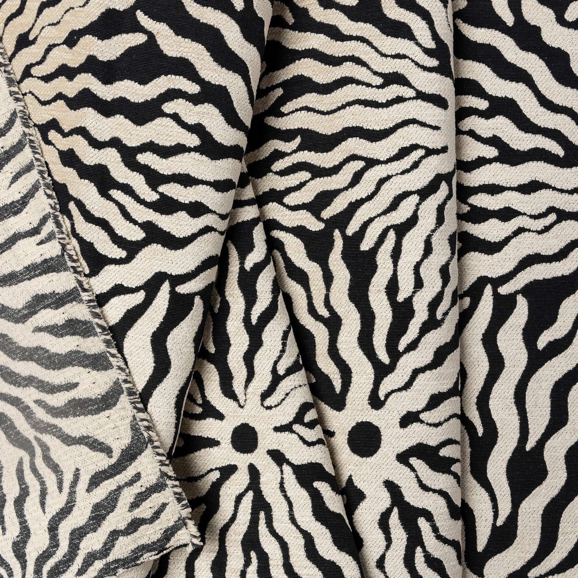 Black and ivory sunburst jacquard upholstery fabric by the yard, folded showing drape and weight