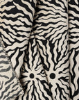 Black and ivory sunburst jacquard upholstery fabric by the yard, folded showing drape and weight