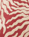 Close-up of woven sunburst pattern on red and cream jacquard throw pillow