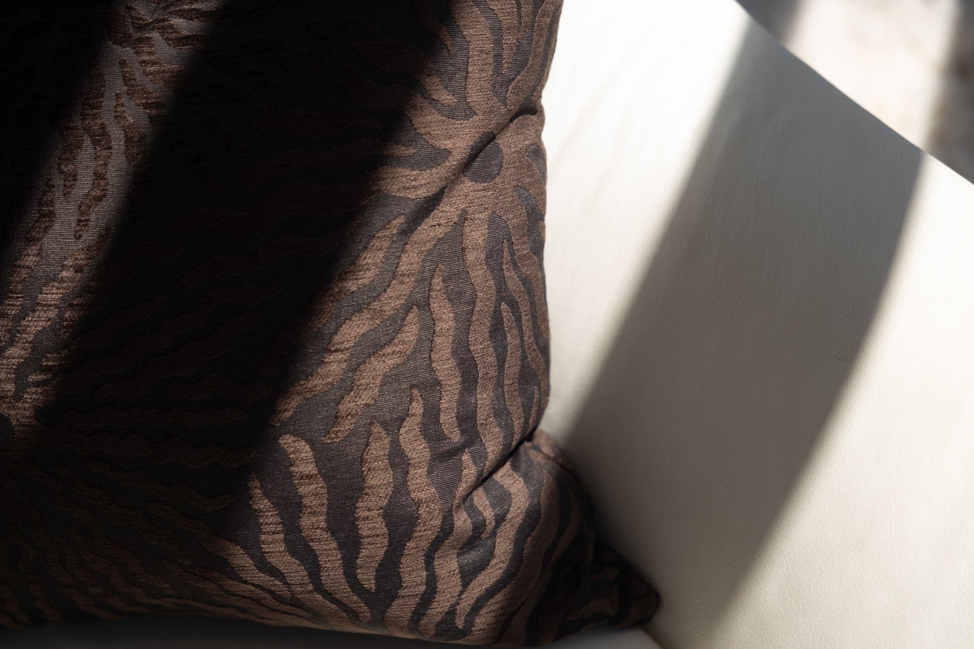 Close-up of woven sunburst pattern on dark brown jacquard throw pillow