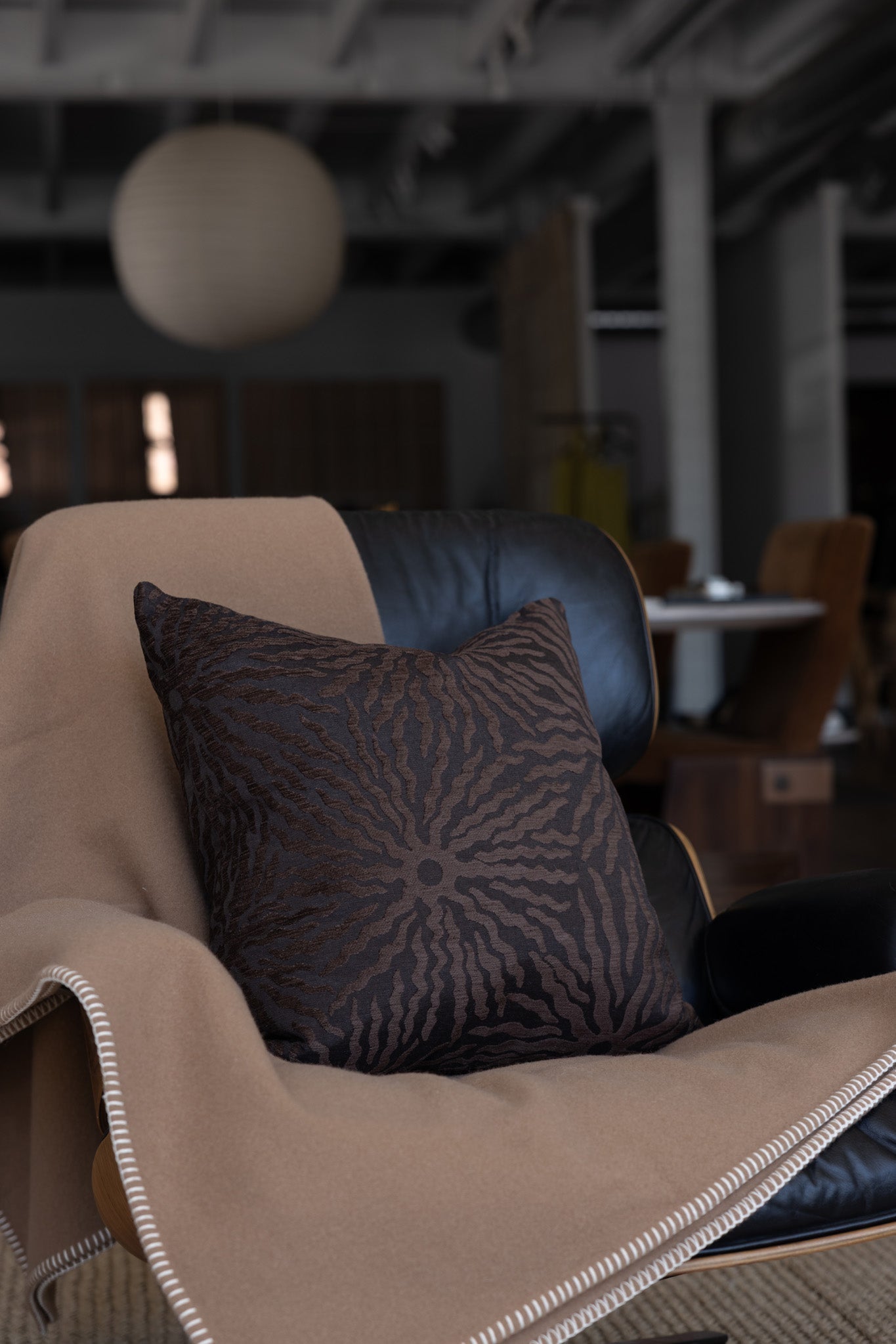 Dark brown sunburst throw pillow styled on white boucle sofa