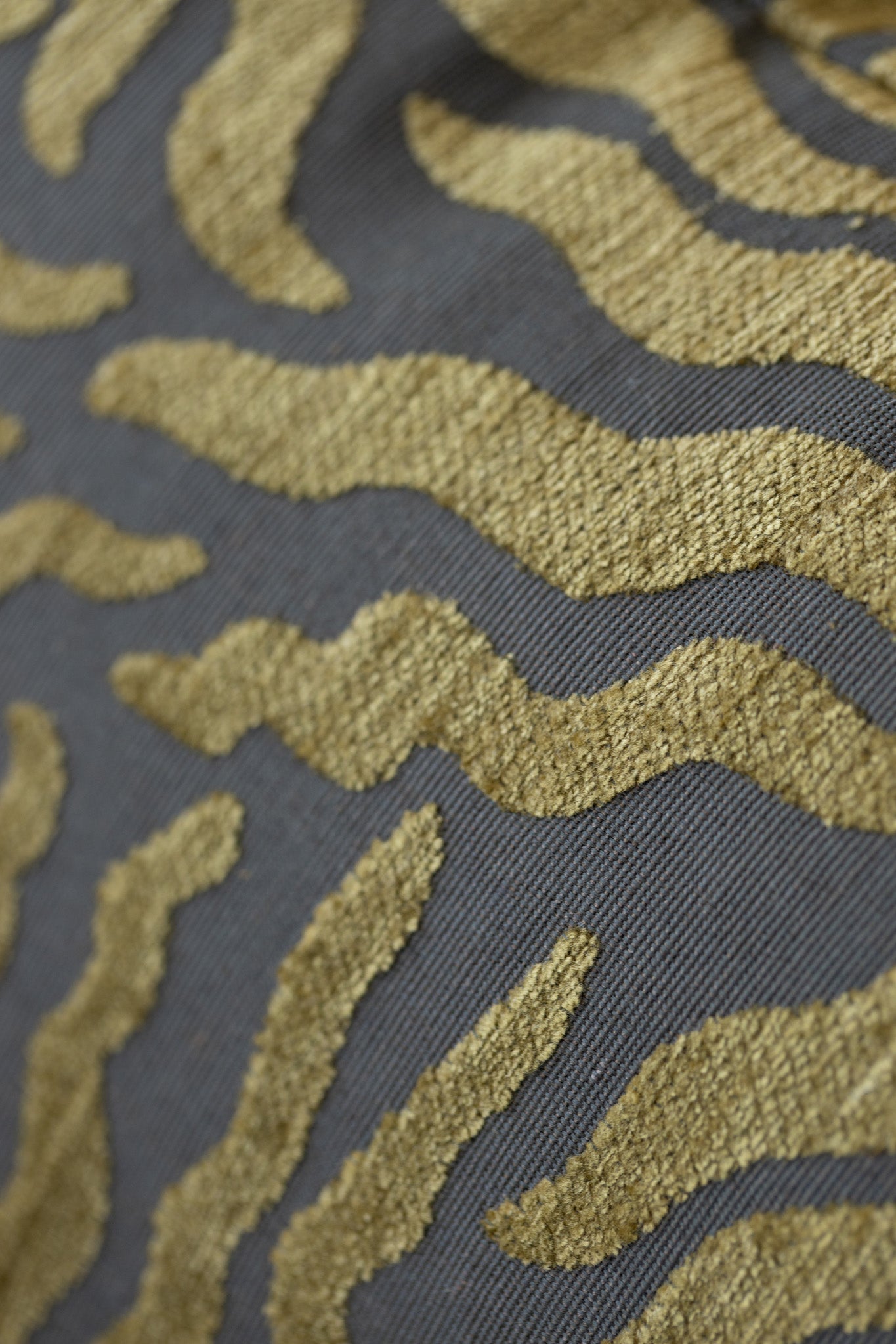 Close-up of woven sunburst pattern on gold and brown jacquard throw pillow