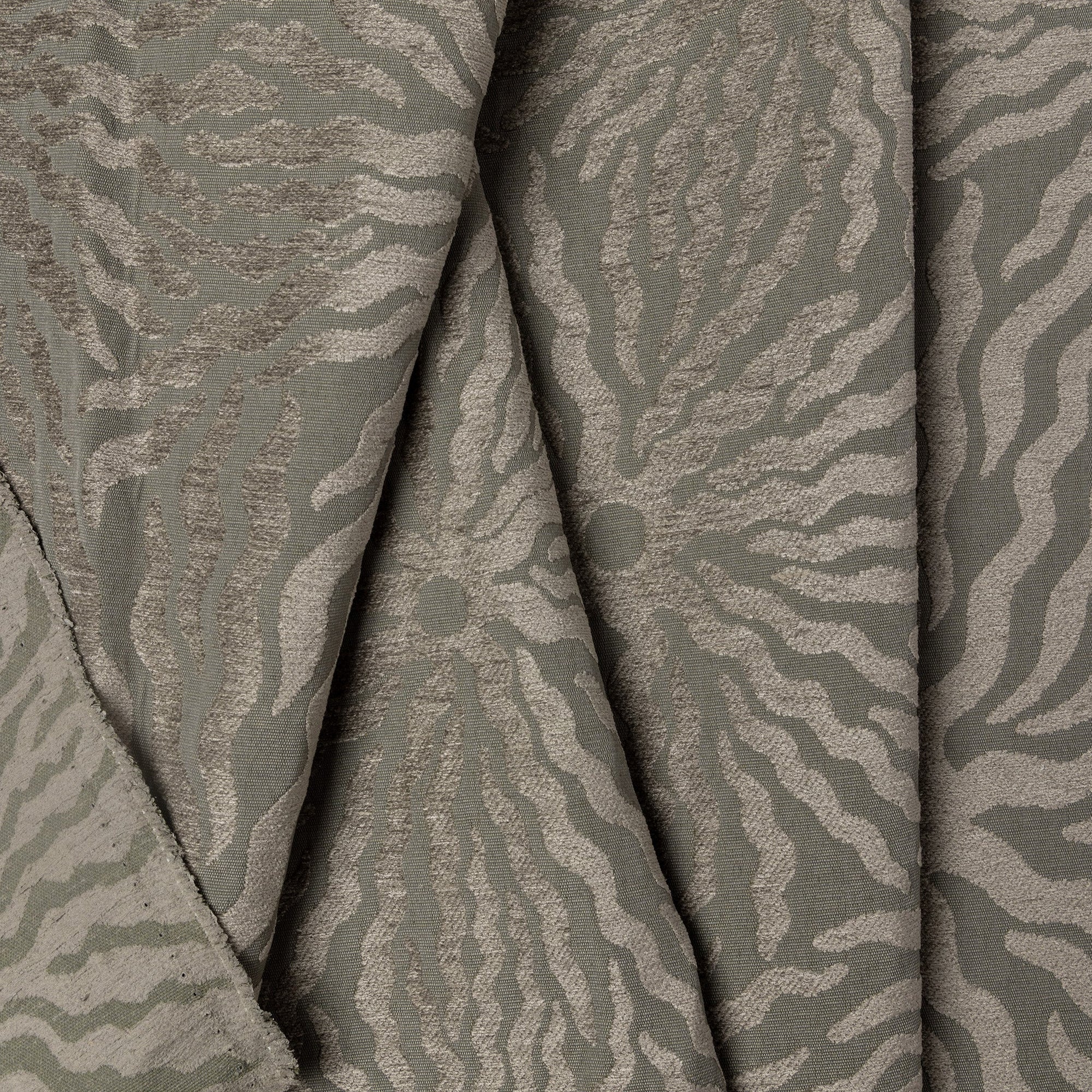 Sage green sunburst jacquard upholstery fabric by the yard, folded showing drape and weight