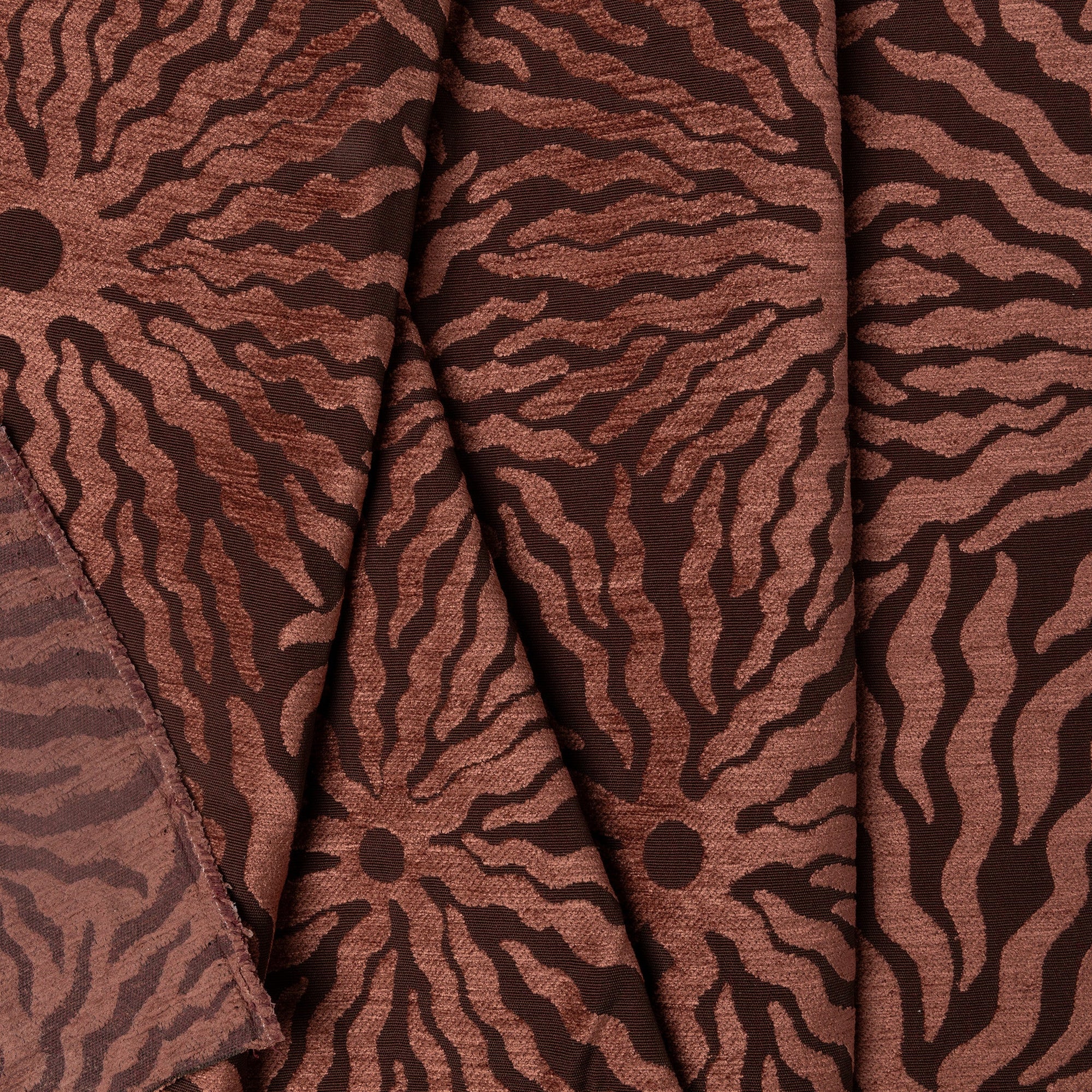Rust sunburst jacquard upholstery fabric by the yard, folded showing drape and weight