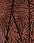 Rust sunburst jacquard upholstery fabric by the yard, folded showing drape and weight