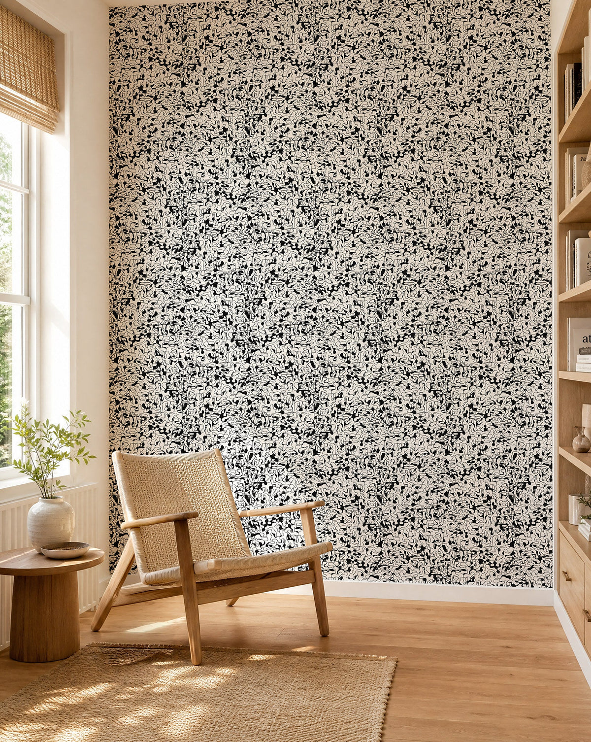 Black and white abstract squiggle wallpaper installed in a sunlit reading nook