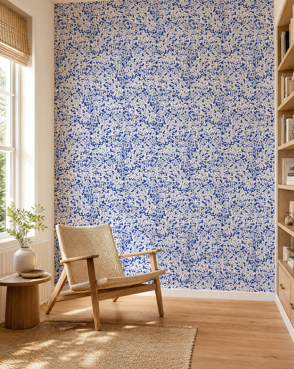 Cobalt blue and white abstract squiggle wallpaper installed in a sunlit reading nook