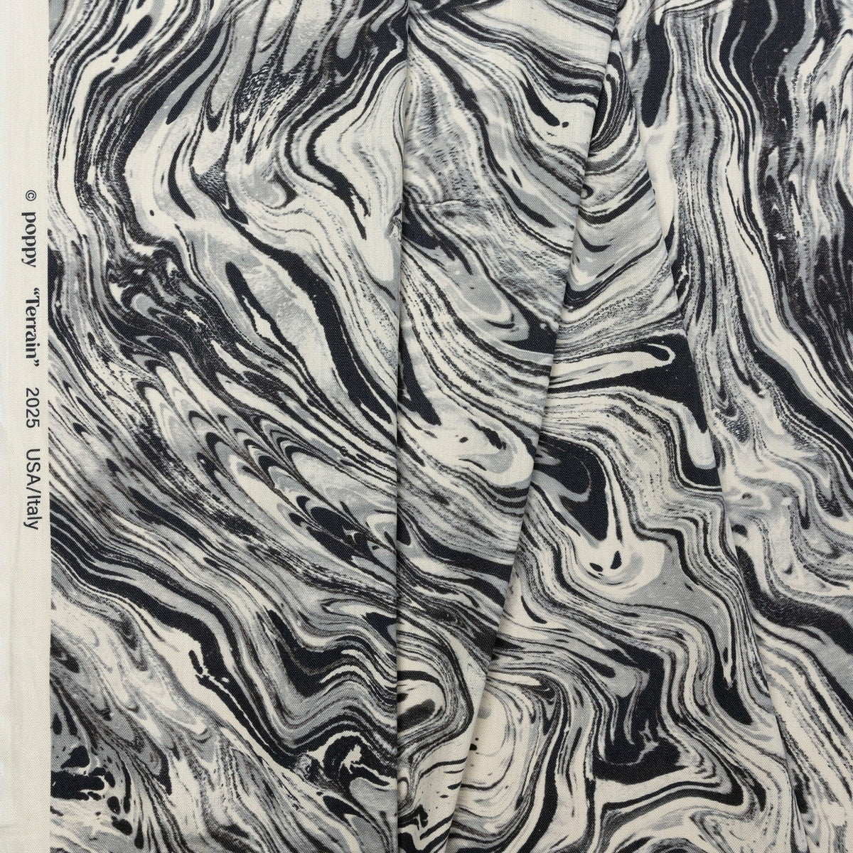 Black and cream marbled abstract linen fabric by the yard, folded showing drape and weight