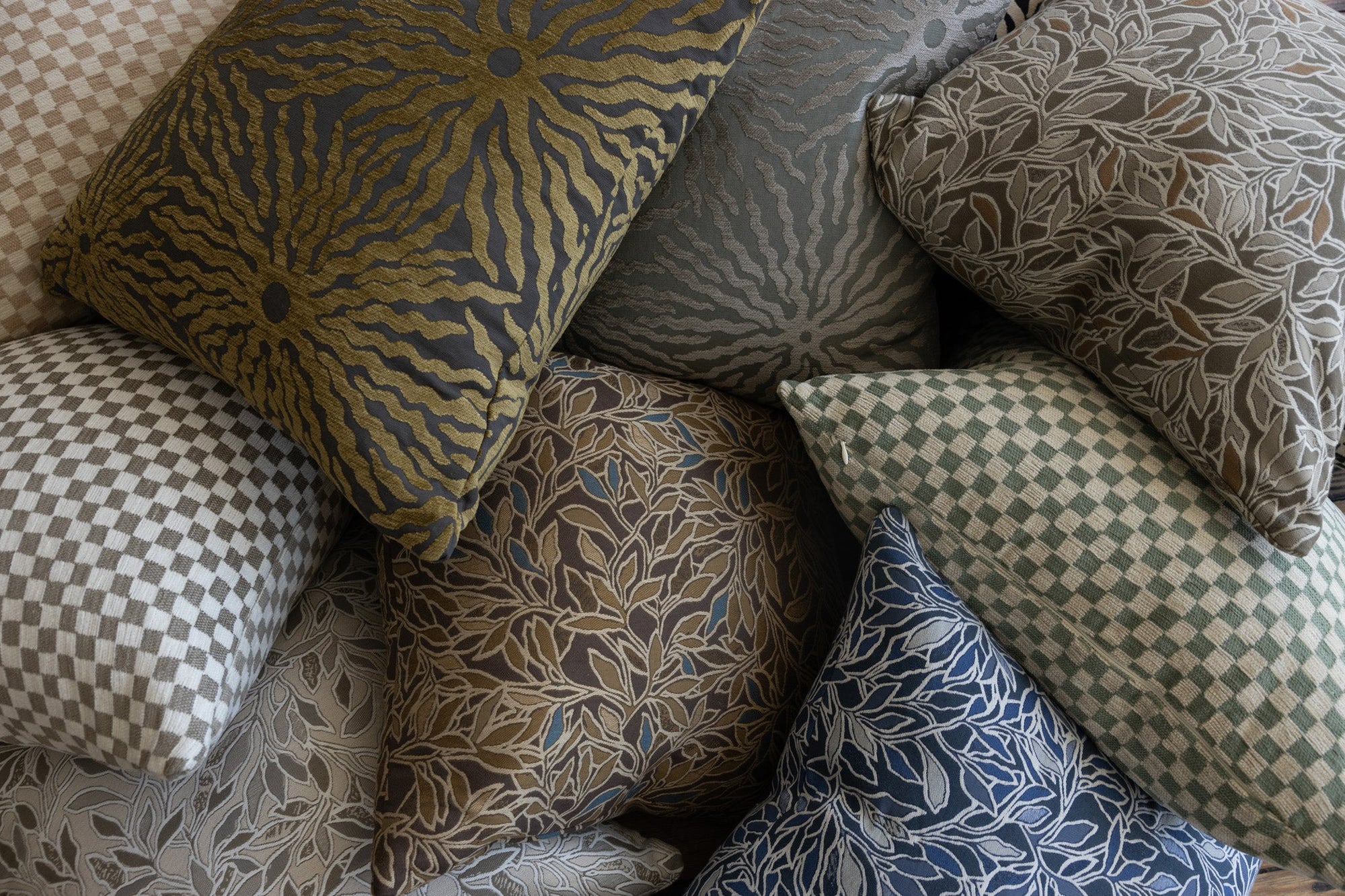 Sage green botanical leaf throw pillow shown with Poppy Print Studio pillow collection on white boucle sofa