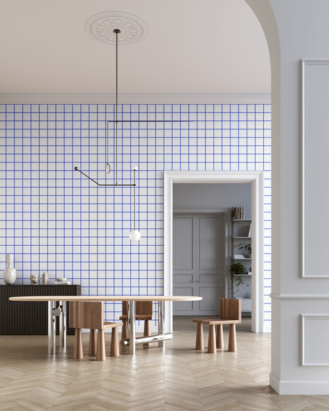 Modern dining room with white and blue grid-patterned wallpaper, a minimalist pendant light, sculptural wooden furniture, and a black sideboard, creating a contemporary and stylish aesthetic.