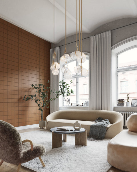Modern living room featuring a warm brown grid-patterned wallpaper, plush cream-colored seating, a shaggy white rug, and a sculptural glass pendant light, creating a cozy yet sophisticated ambiance.