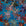 Abstract patterned blue floral wallpaper with overlapping multicolored flowers, creating a layered and textured effect.