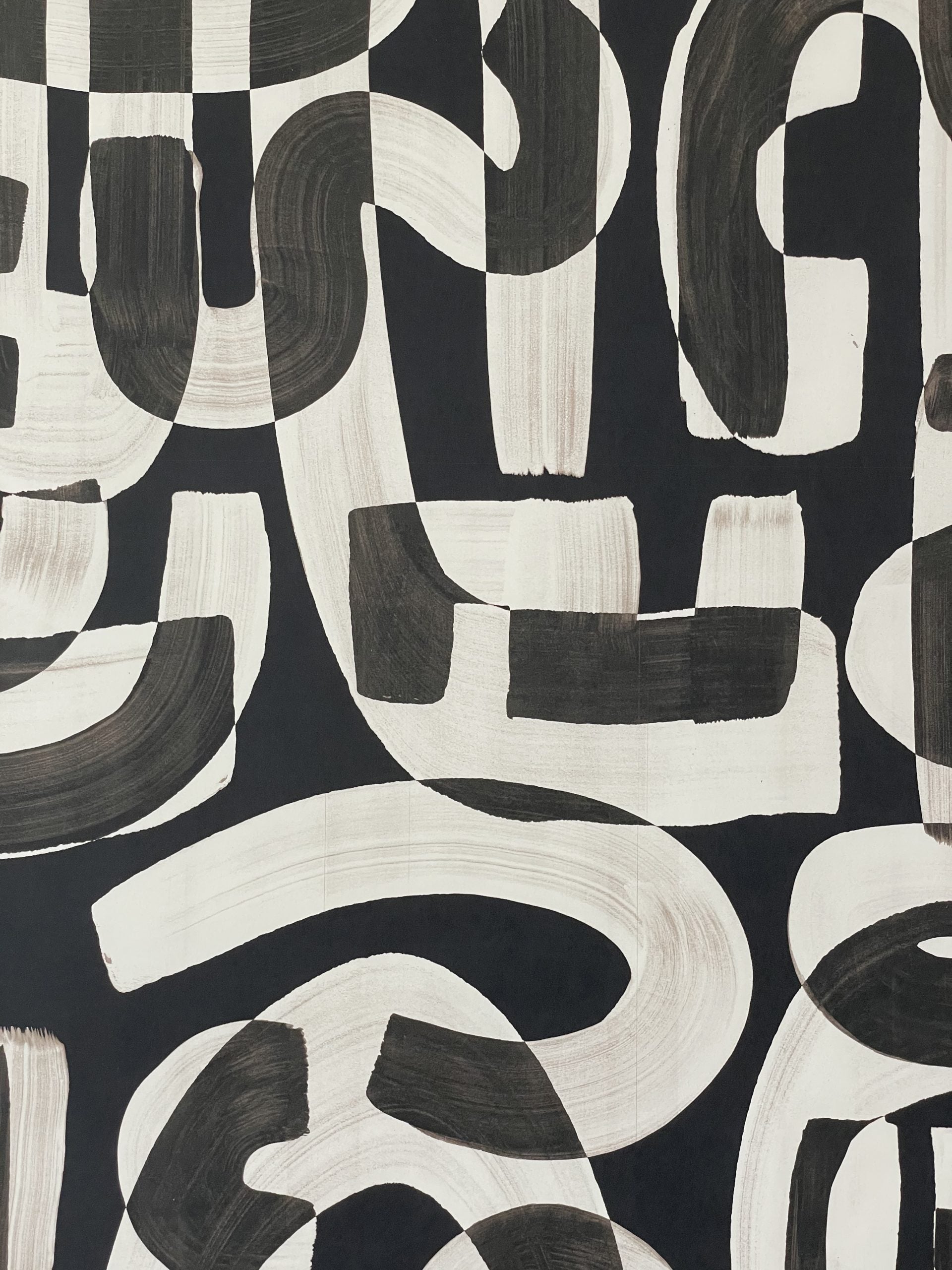 Close-up of black and white abstract wallpaper with bold, sweeping brushstrokes creating a dynamic, modern pattern.