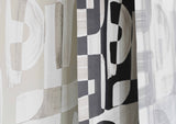 Angled shot showing the edges of black and white, tan, and green Down the Rabbit Hole wallpaper