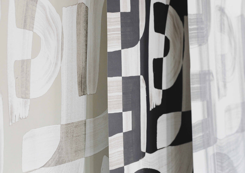 Angled shot showing the edges of black and white, tan, and green Down the Rabbit Hole wallpaper